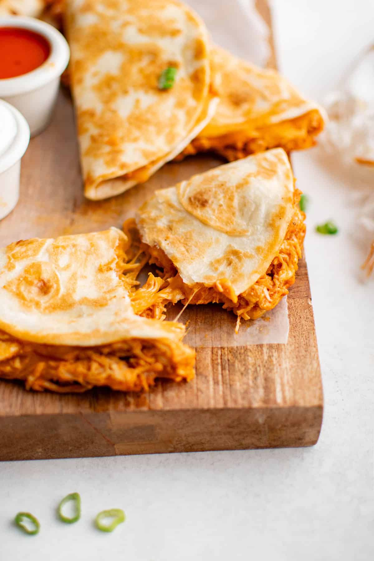 a crockpot buffalo chicken taco ripped in half on a serving platter