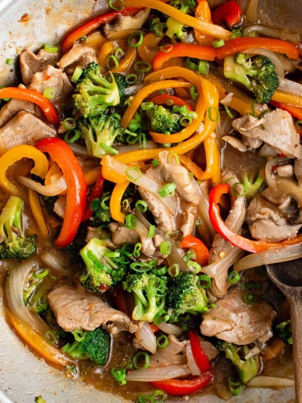 photo of pork stir fry in a pan with a wooden spoon