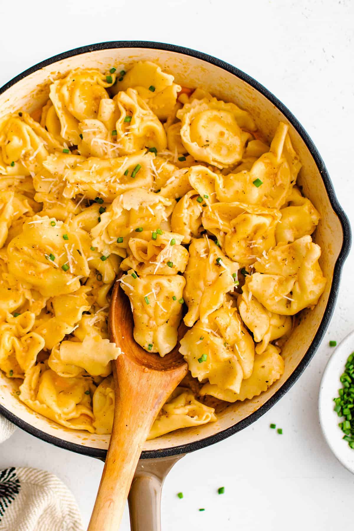 photo of Cajun garlic butter tortellini in a pan with a wooden spoon
