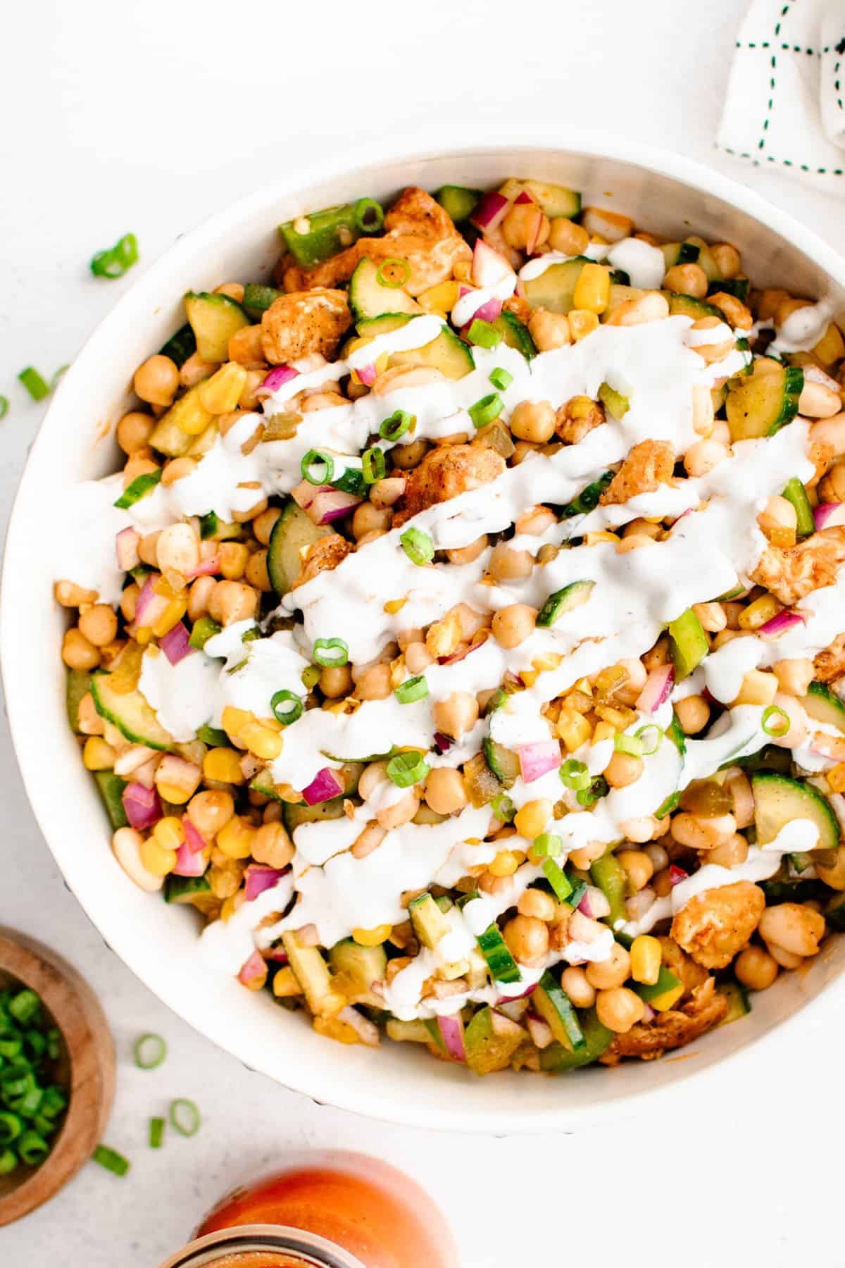 Buffalo Chicken Bean Salad in a serving bowl with ranch dressing drizzled over the top