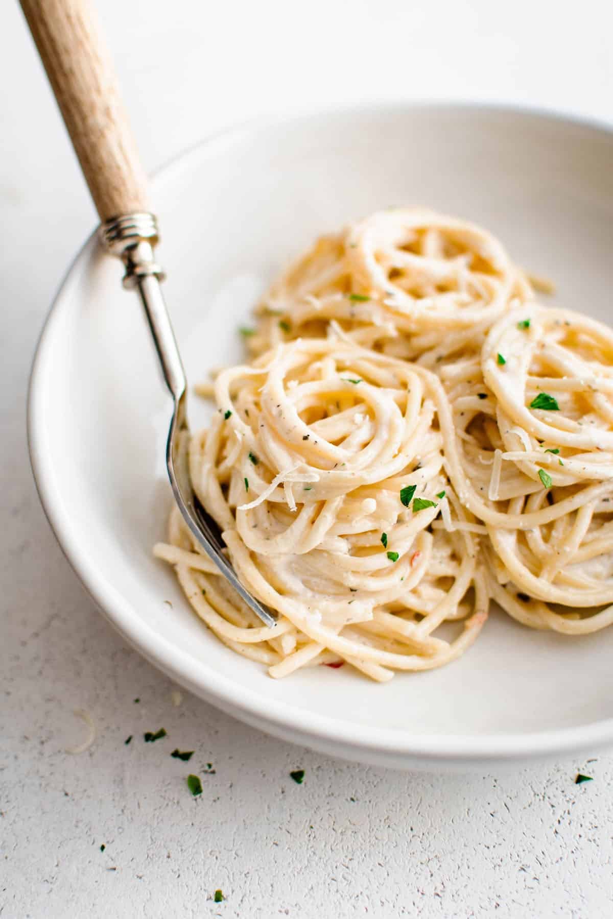 cream cheese pasta on a plate with a fork underneath the pasta
