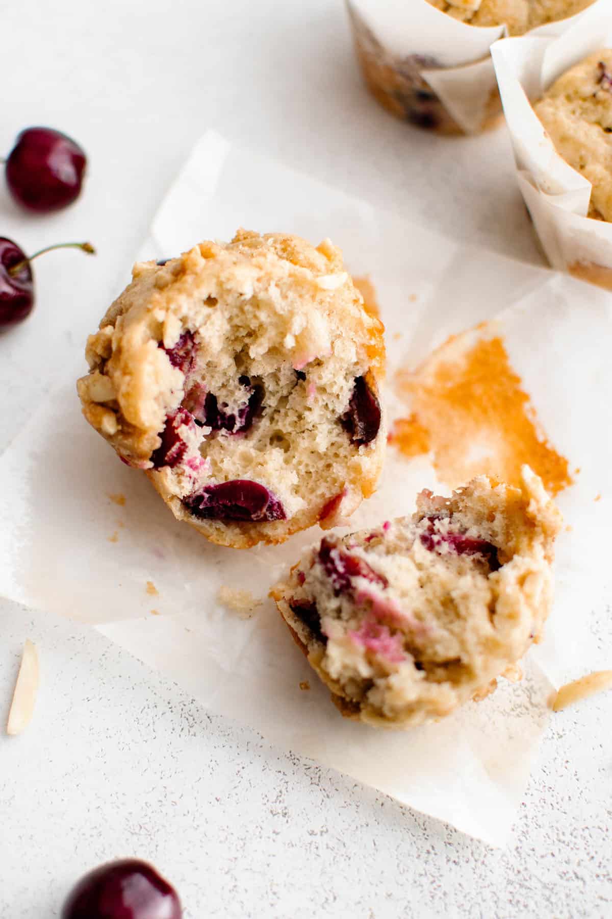 a summer cherry muffin split open so the viewer can see the texture of the dough and streusel topping