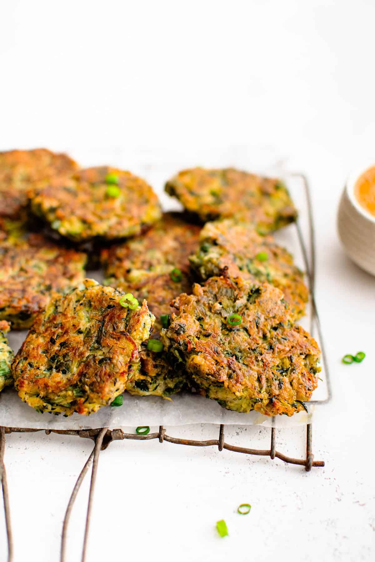 zucchini fritters stacked on cooling rack