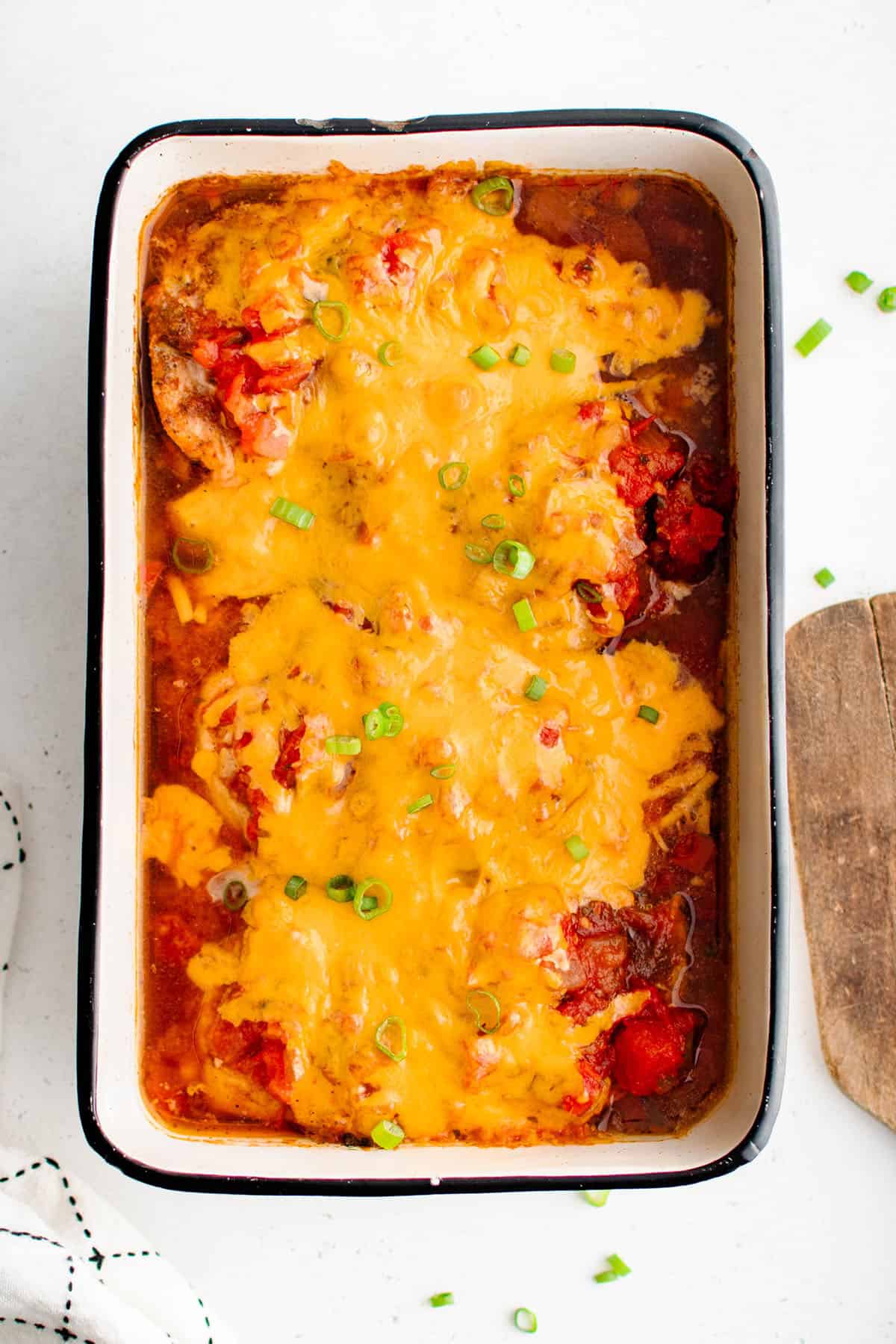 baked salsa chicken in a baking dish and garnished with sliced green onions