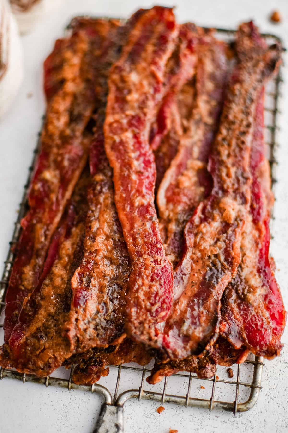candied bacon piled high on a cooling rack