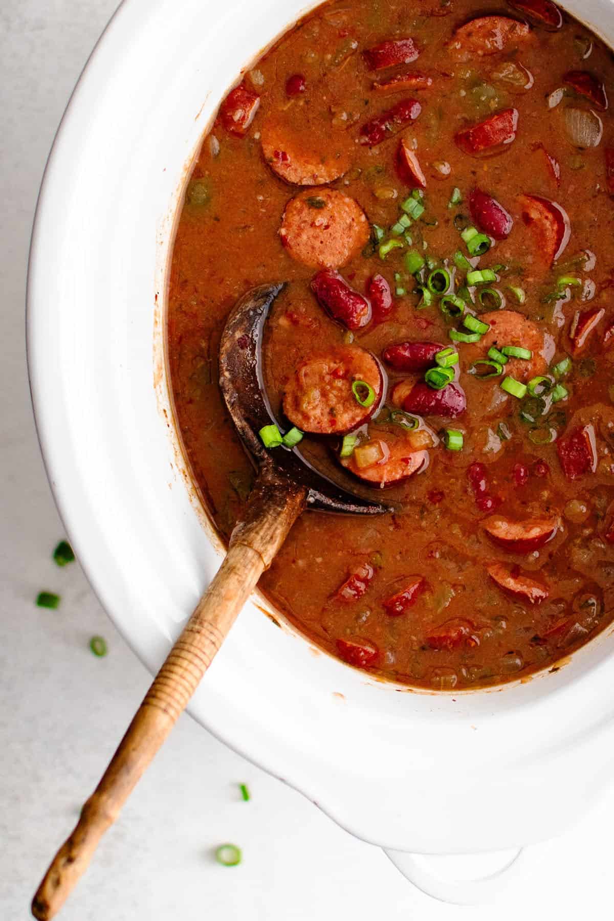 crockpot red beans and rice in a slow cooker garnished with green onions