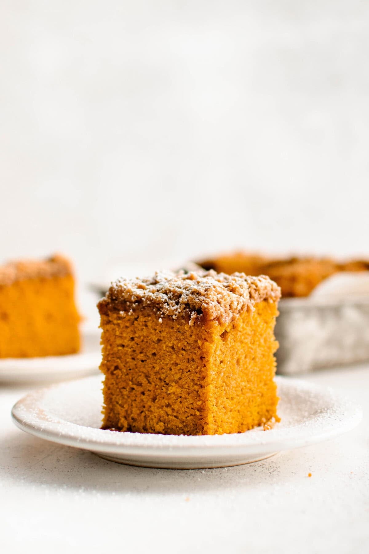 a slice of pumpkin coffee cake topped with powdered sugar