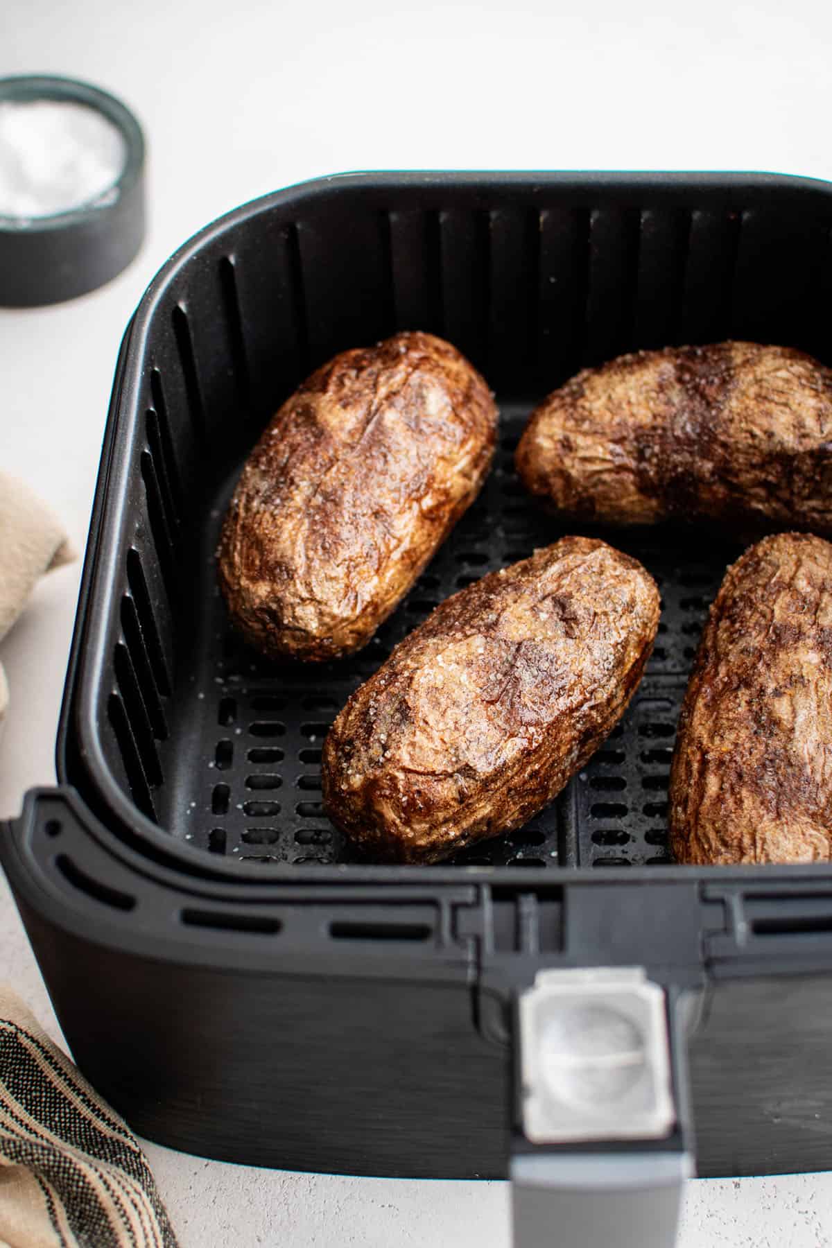 air fryer baked potatoes in an air fryer basket